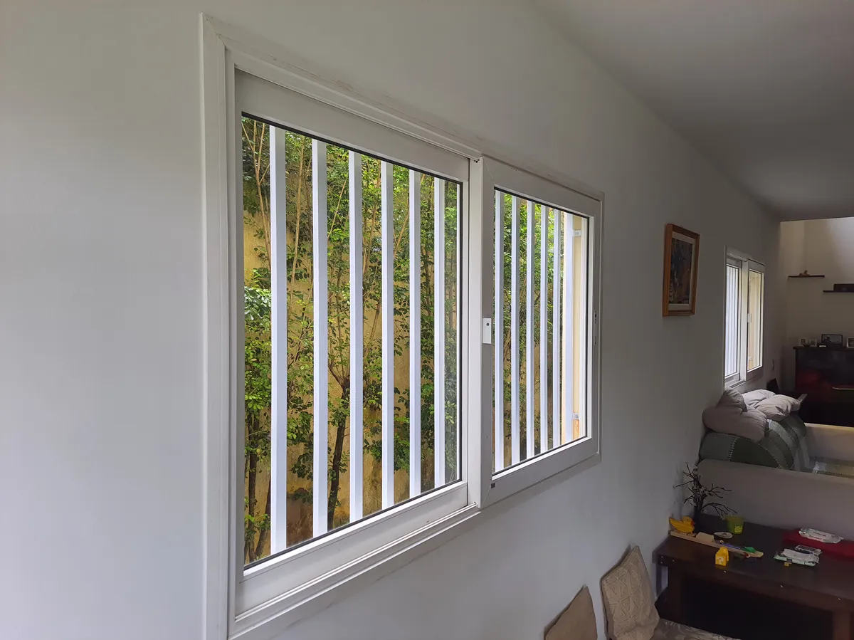 Foto Interna Como Fica A Grade de Ferro para Janela Olhando de Dentro da Casa A Grade Foi Feita com Metalon Diagonal Pintada na Cor Branca